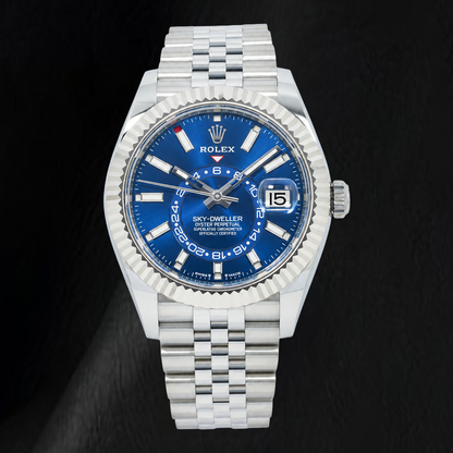 A Rolex Sky-Dweller Datejust watch with a silver stainless steel Oyster bracelet and a vibrant blue dial, shown against a dark textured background.