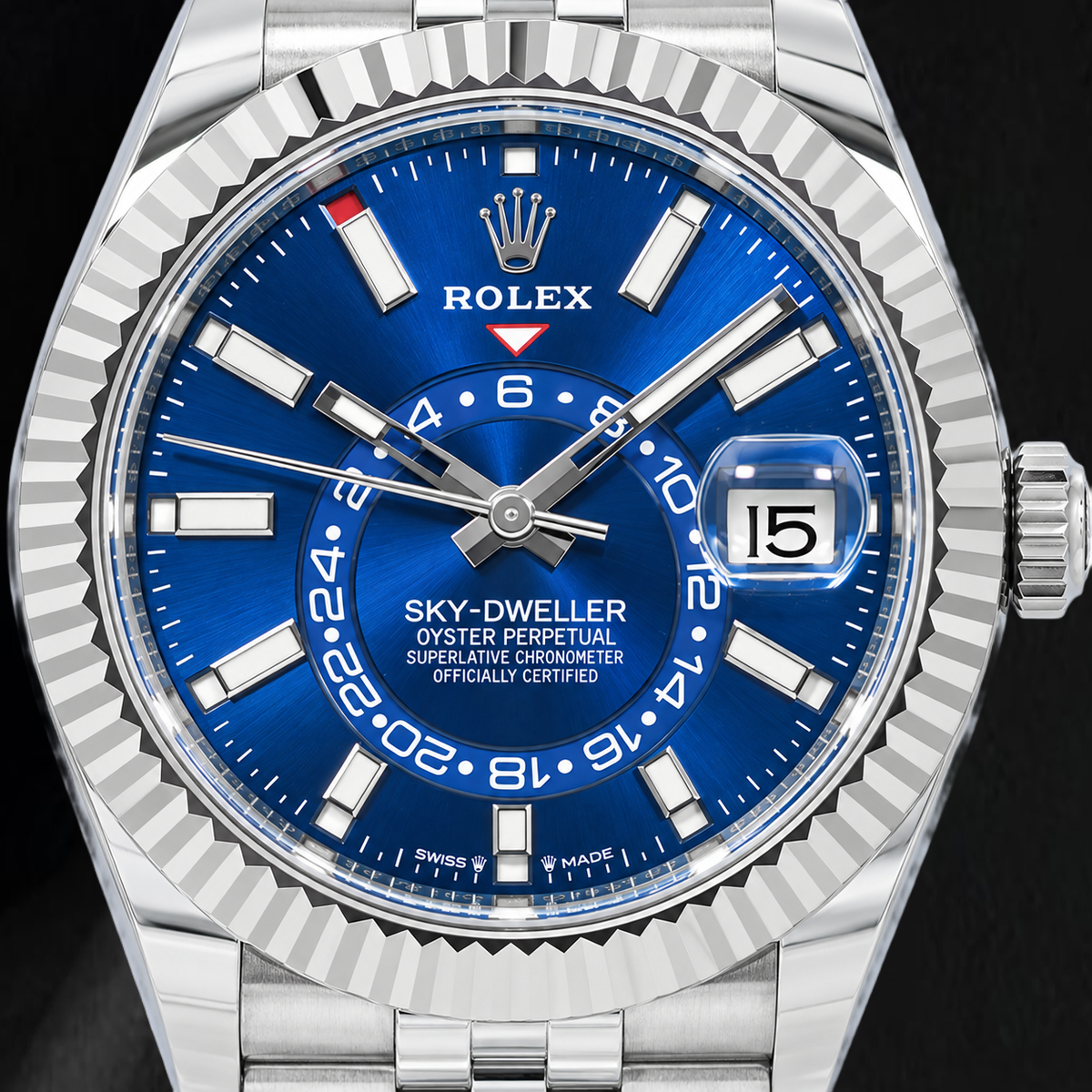 Close-up of a Rolex Sky-Dweller Oyster Perpetual watch with a vibrant blue dial, silver stainless steel case, and fluted bezel on a dark background.